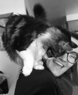 smiling woman with a cat on her shoulder 