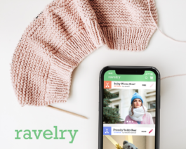 A knitting project and a phone with the ravelry app open 